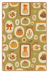 Harvest rug with pumpkins, bows, and leaves on green background.